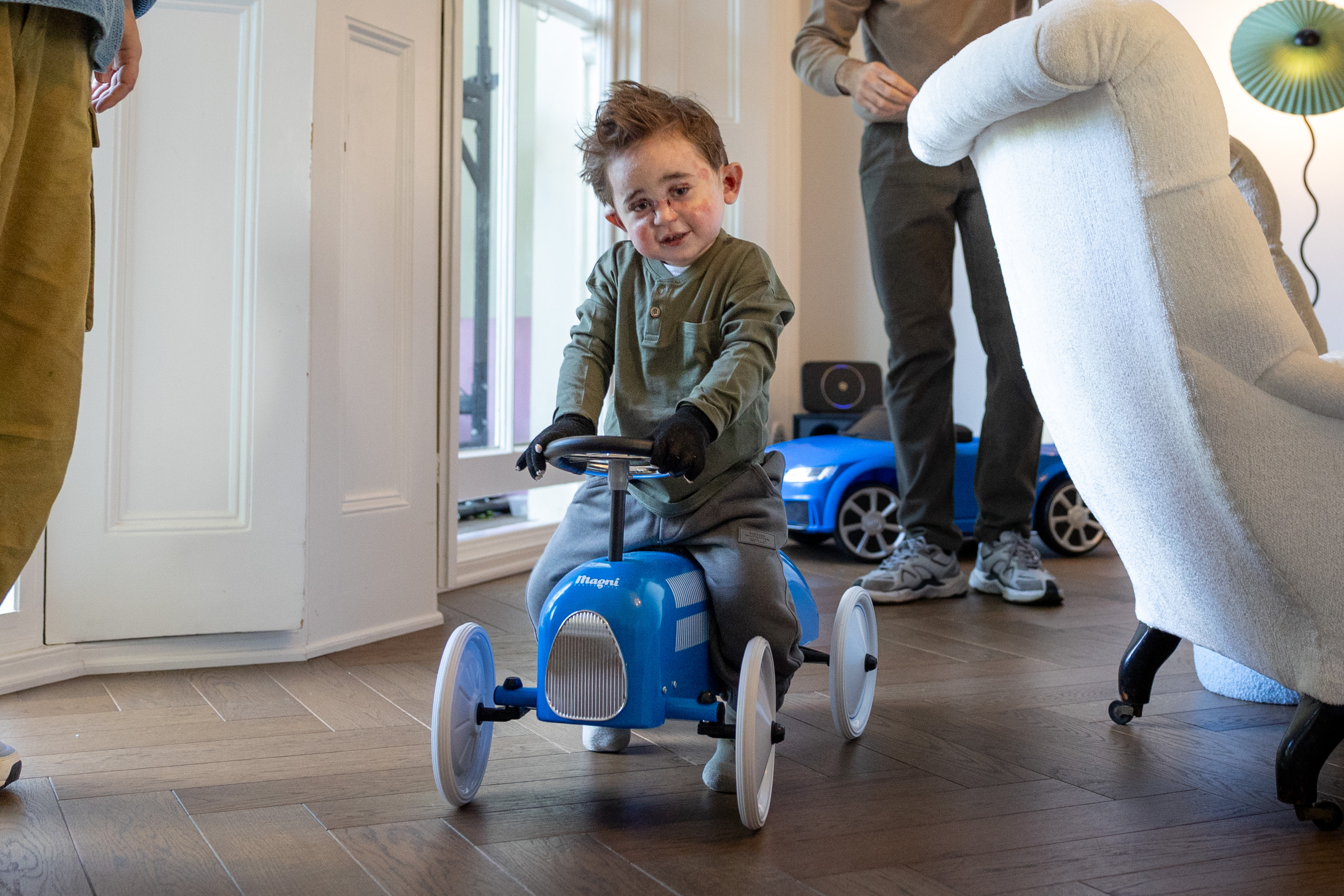 A young boy with epidermolysis bullosa (EB) playing with a toy car.