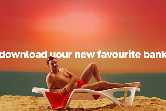 Monzo bank advertisement: man relaxing on a beach lounger, text overlay: 