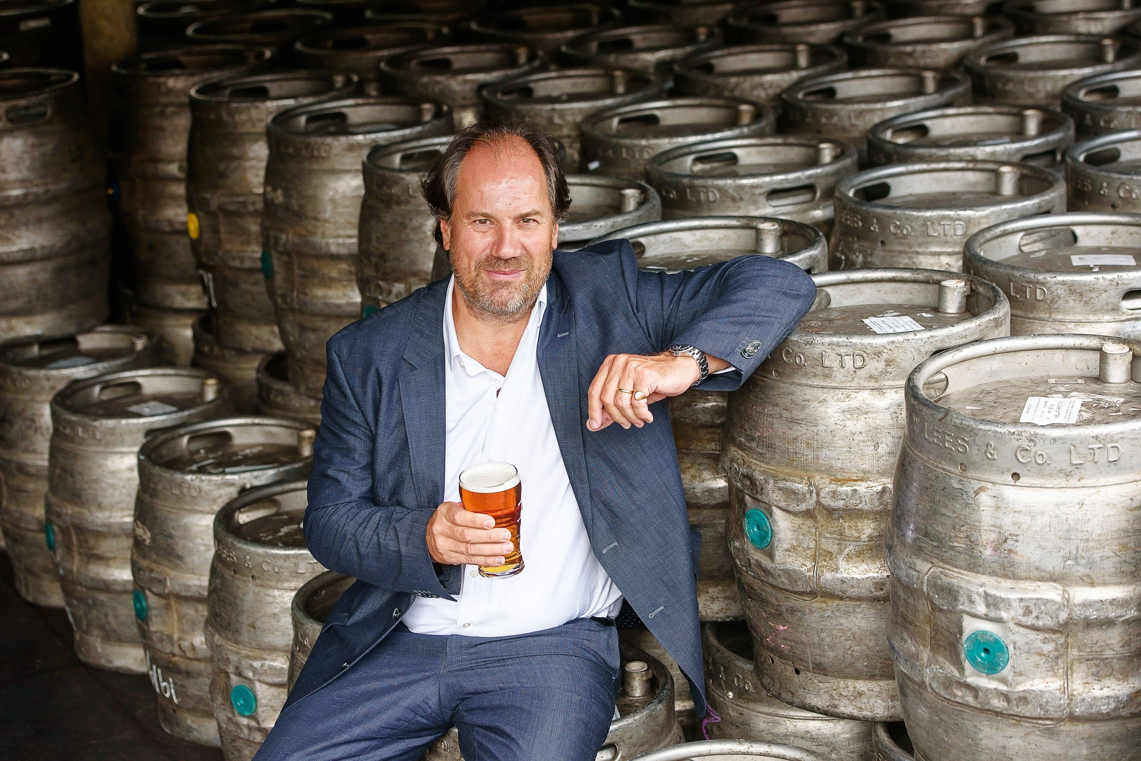 William Lees-Jones, MD of JW Lees Brewery, holding a pint of beer.